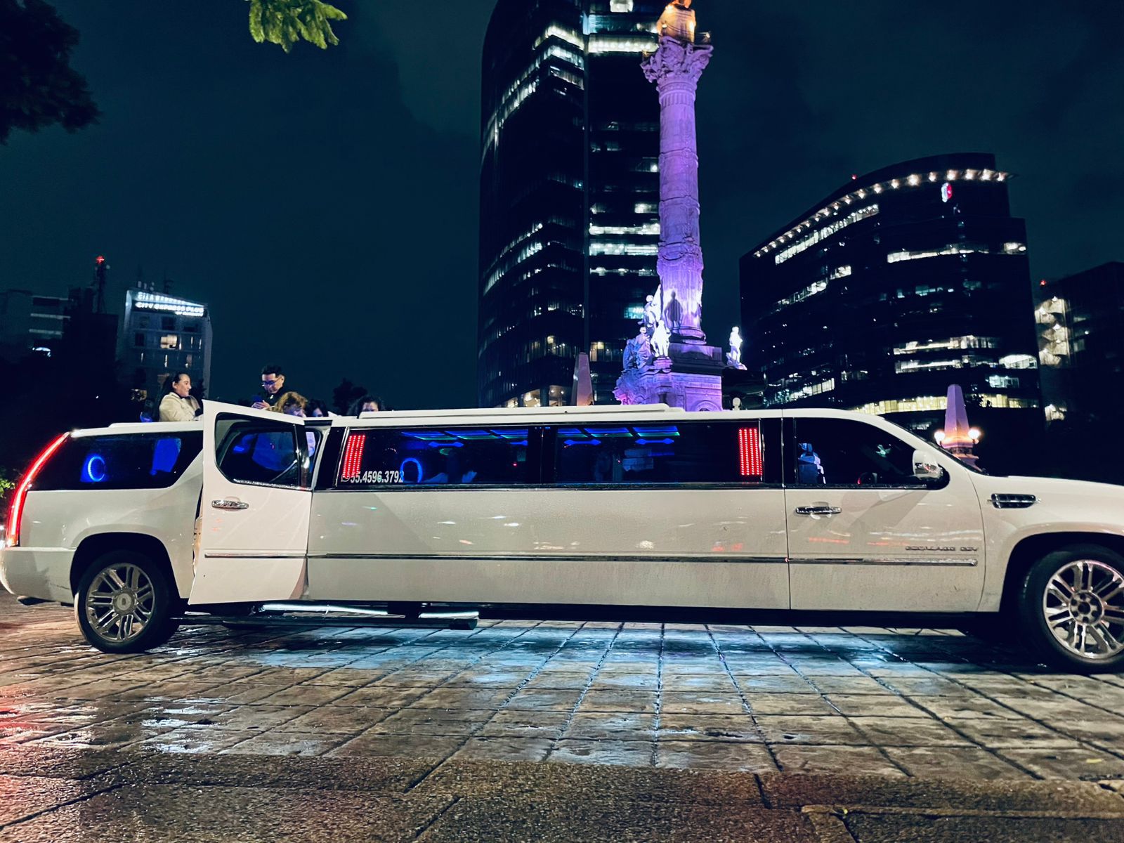 Limusina sedan color blanco enfrente del ángel de la independencia de la CDMX